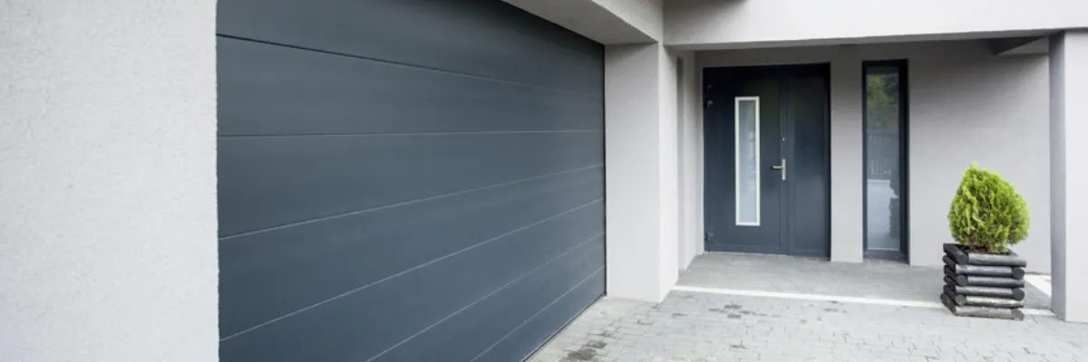A grey automatic garage door, as seen from the outside.