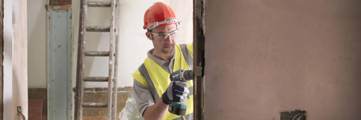 A builder installing a wooden door frame.