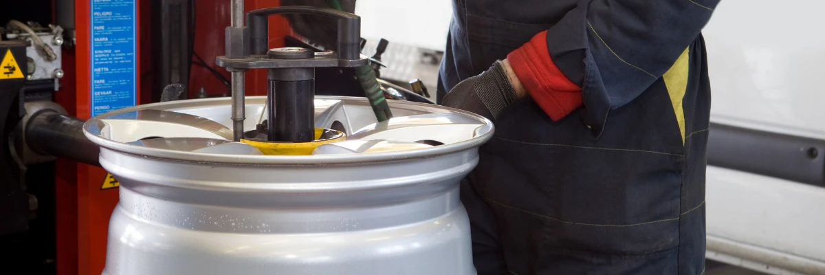 A technician working on a detached wheel alloy.