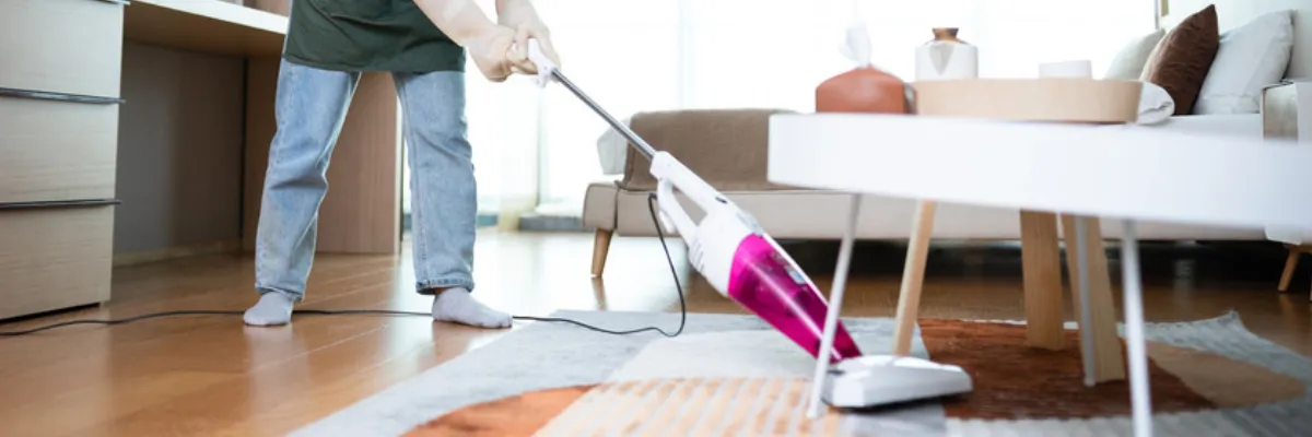 A cleaner vacuuming a rug.