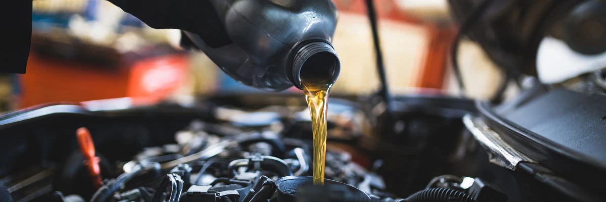 A person refilling engine oil for a car.