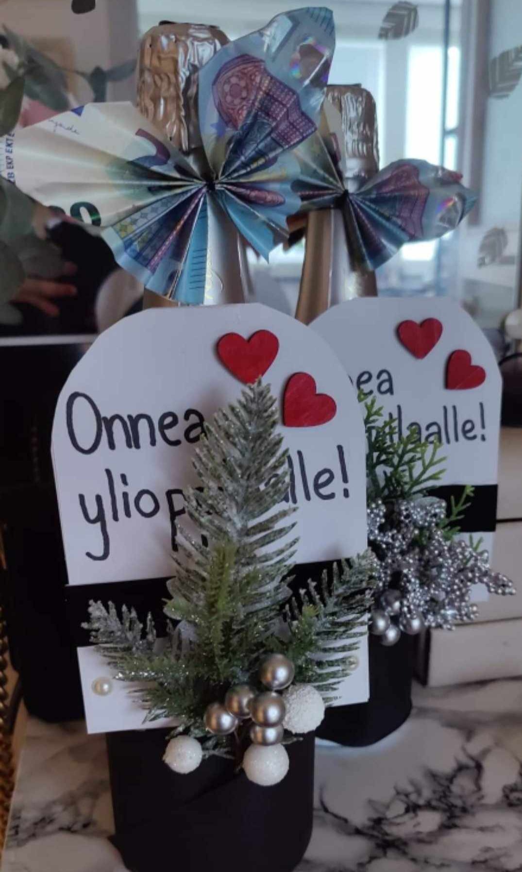 Rahaperhoset skumppapullon kaulalla.