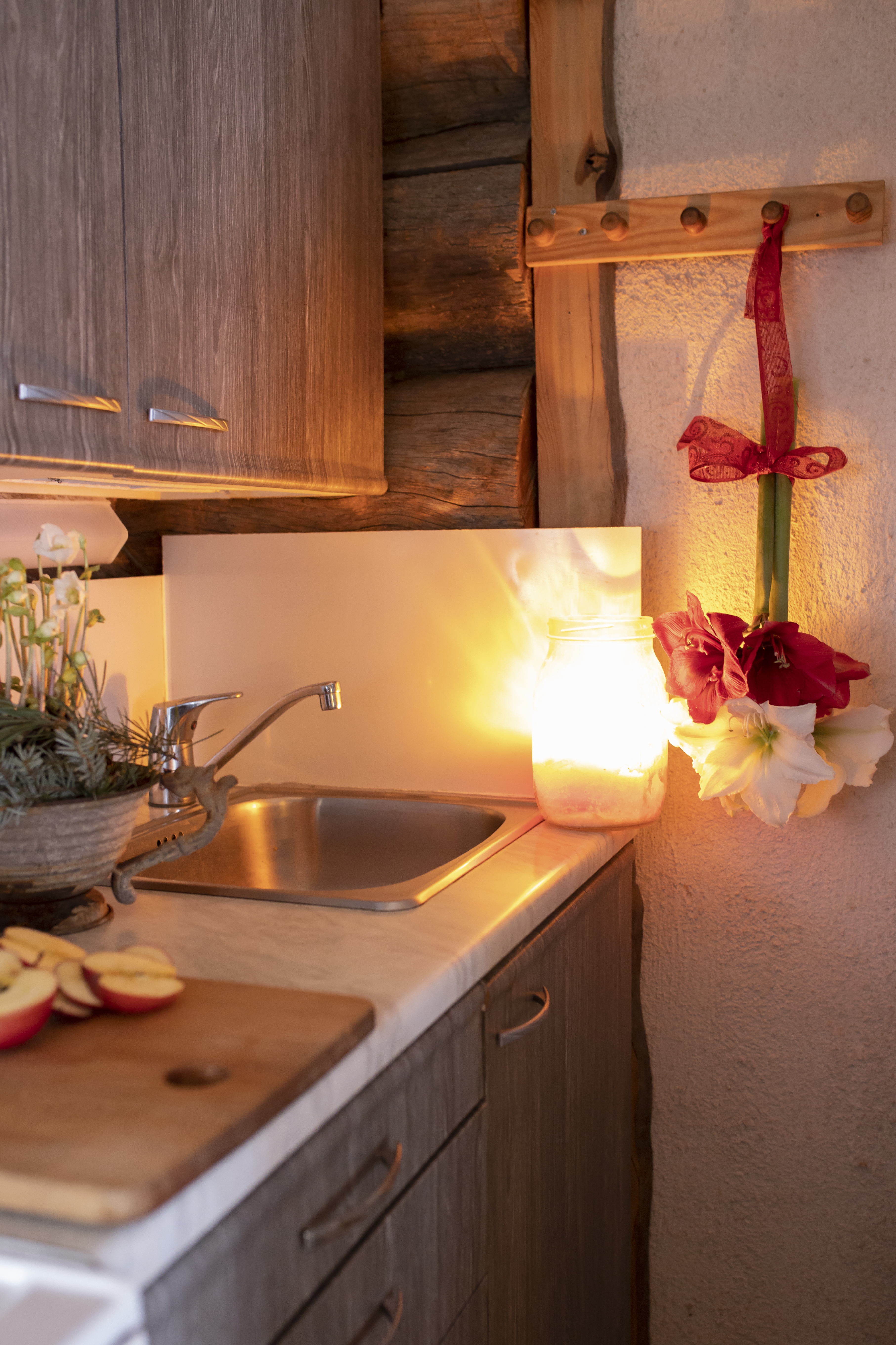 Mökkikeittiö ja seinällä roikkuva amarylliksen kukka.