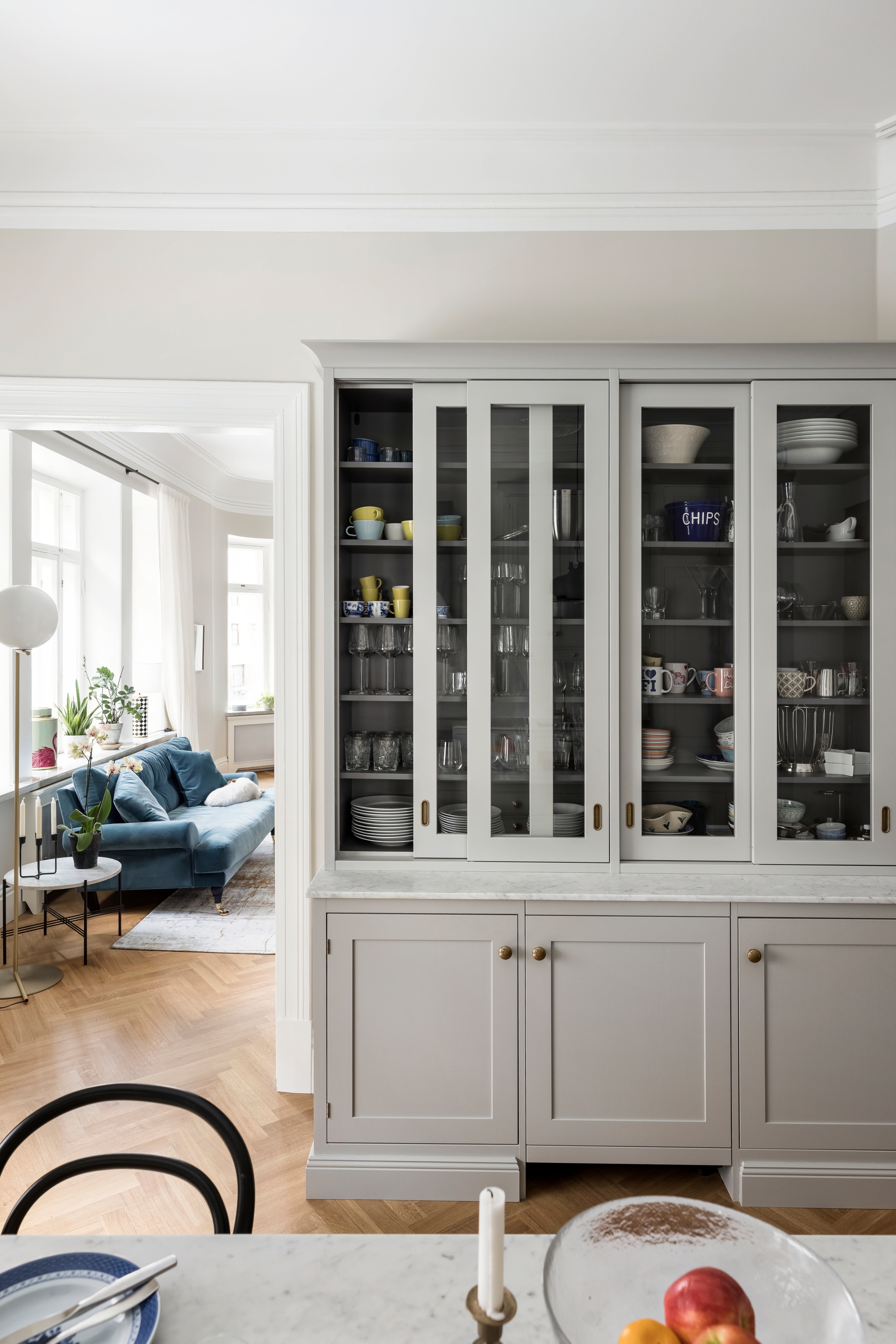 A classic kitchen dish cabinet with glass doors that slide to the sides