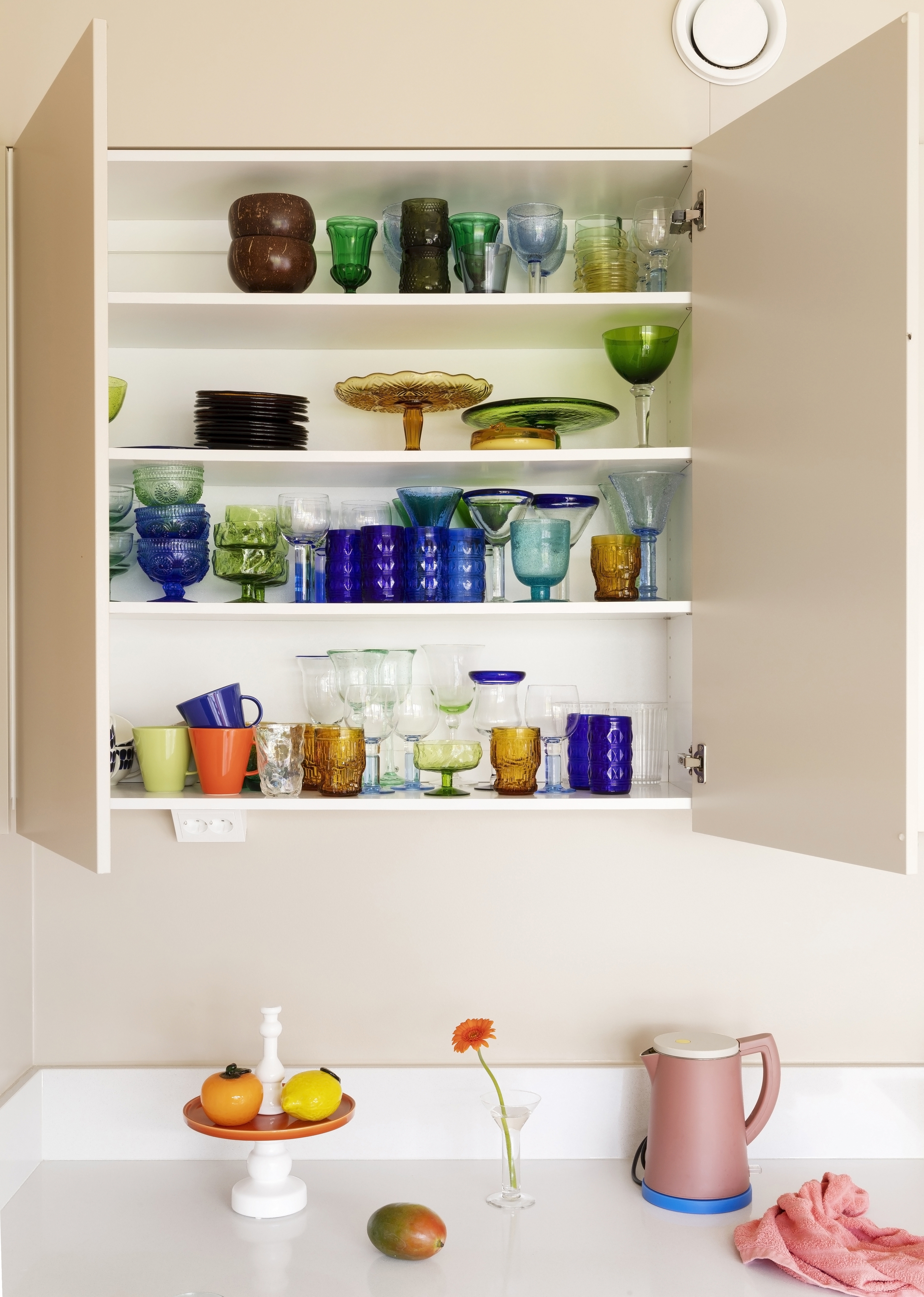 A colored glass collection in the kitchen’s upper cabinet