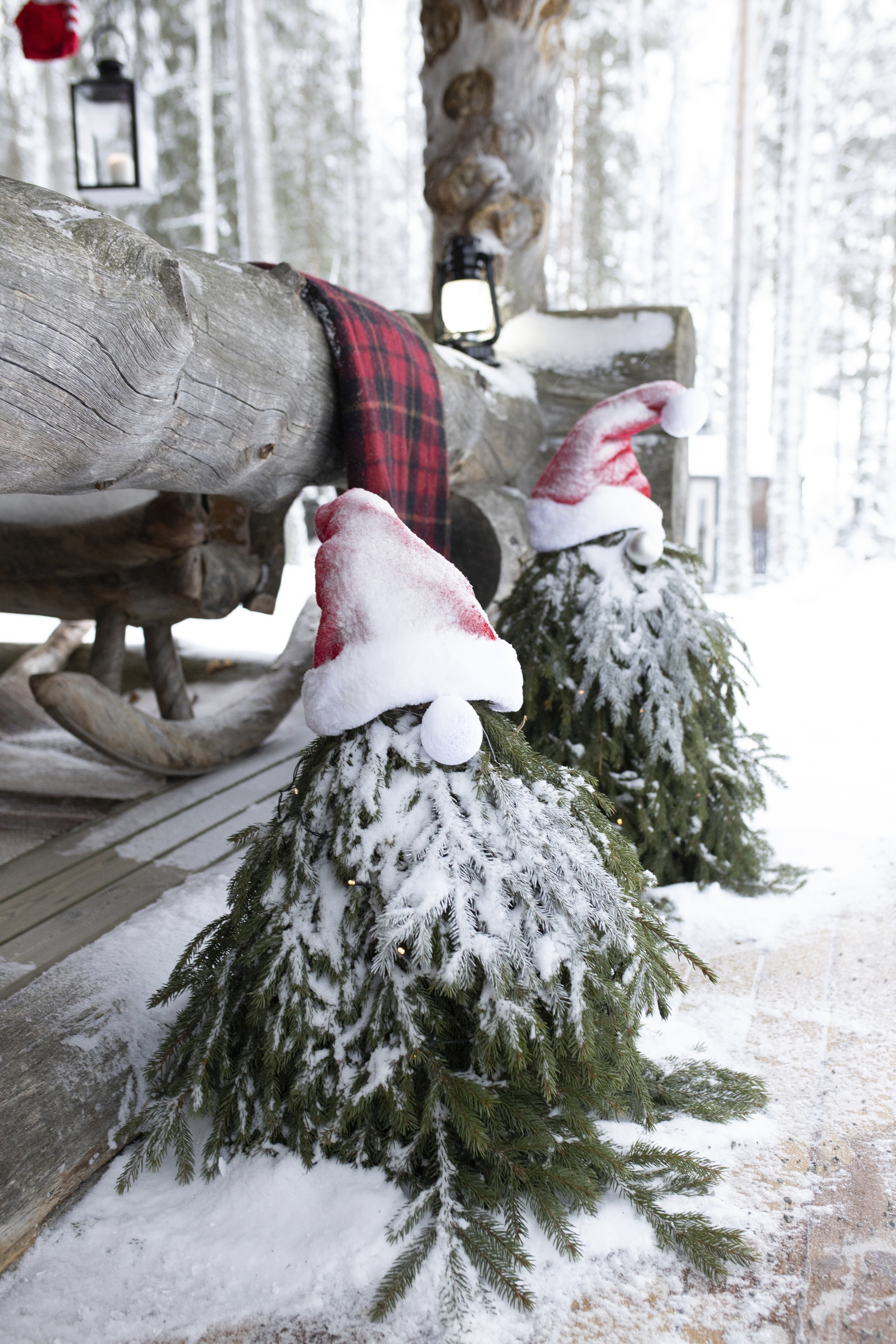 Havusta tehdyt tonttukoristeet mökin terassin edessä.