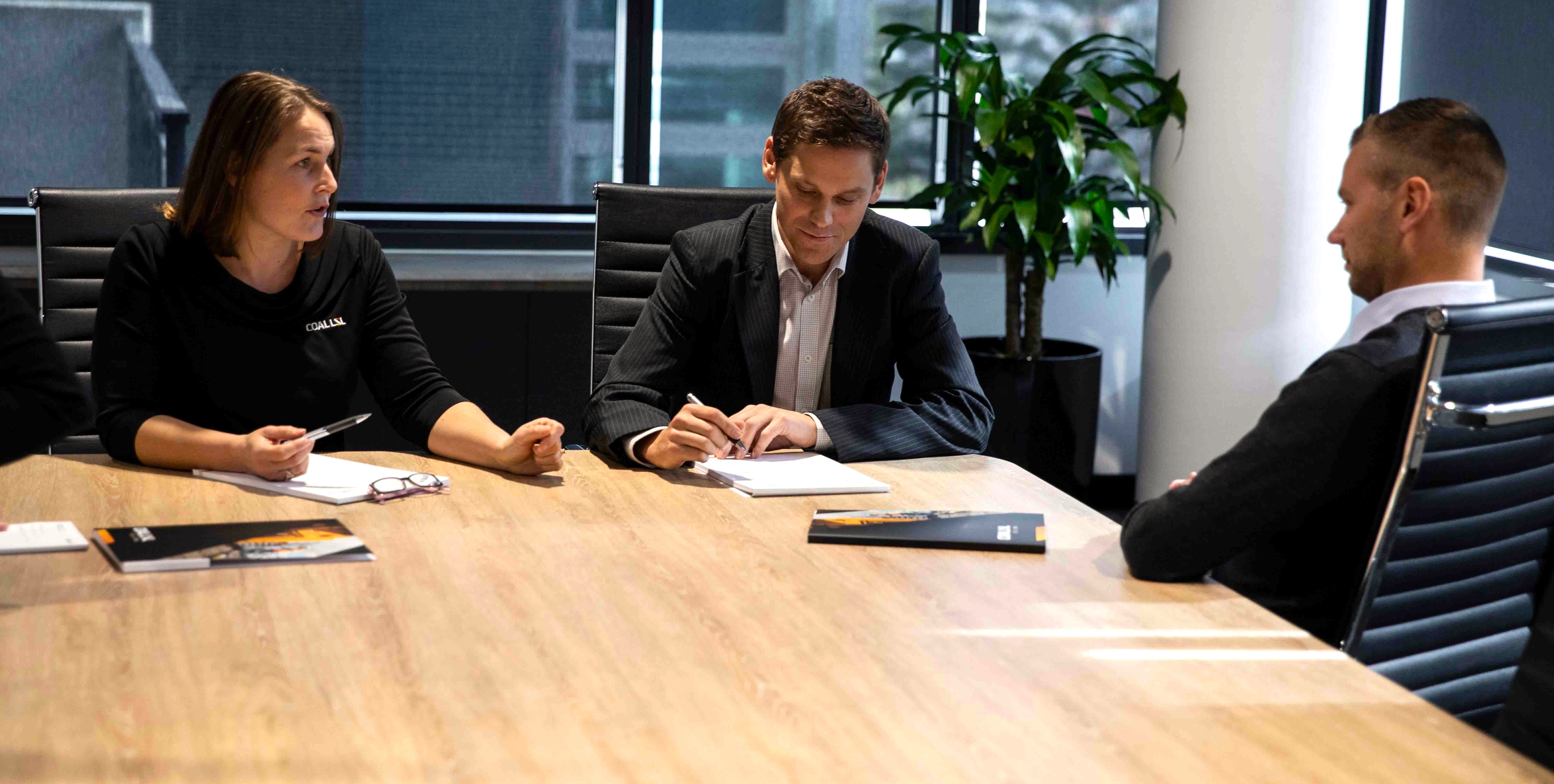 Business people sitting around a boardroom meeting table.