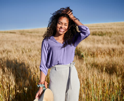 Caucasian blonde woman with curly hair drinking coffe out of a mug