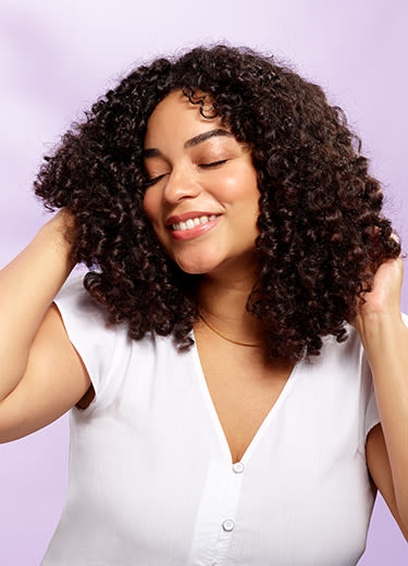 black haired woman smiling over a blue background