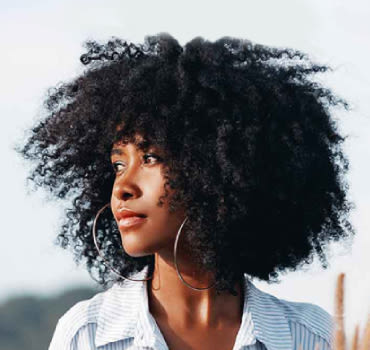 Afro-American woman with curly hair looking sideways