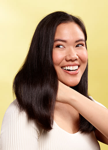 asian woman smiling on a yellow background