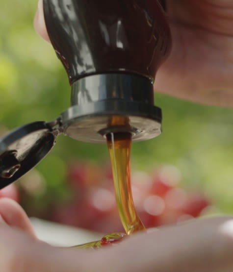 Herbal Essences Grapefruit & Mint Shampoo bottle laying on a bunch of sliced grapefruits and mint leaves