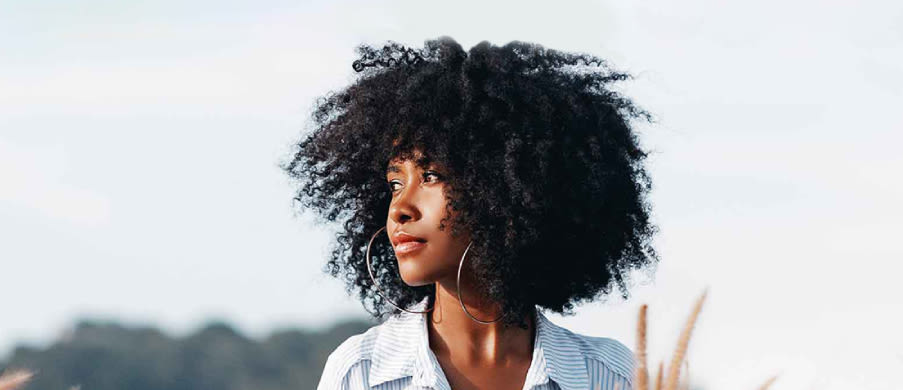 Afro-American woman with curly hair looking sideways