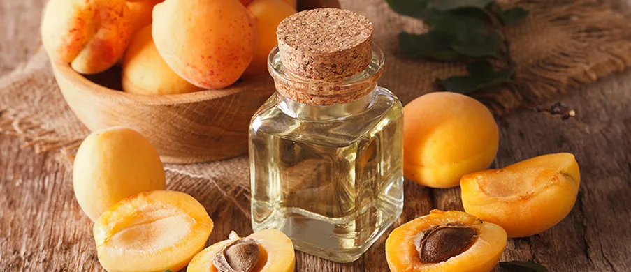 Apricot kernel oil in a glass jar closeup on the table and ingredients