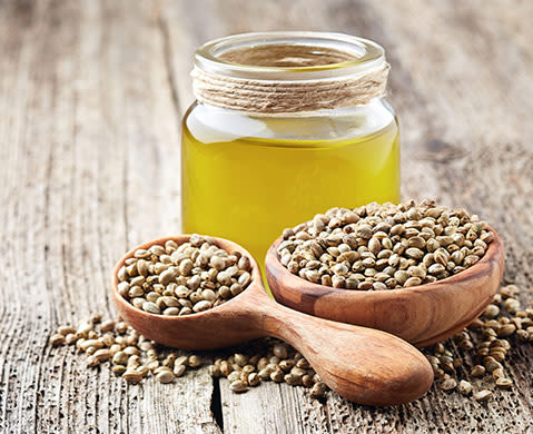 Hemp raw oil and seeds on wooden board