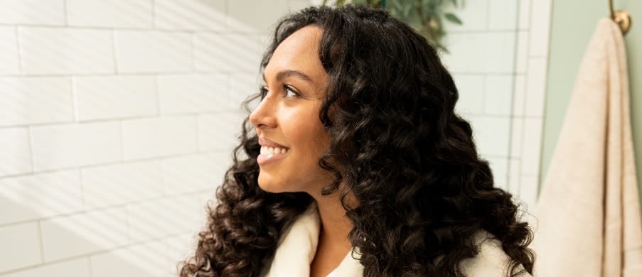 Caucasian brown-haired woman with winter hat and jacket smiling in the snow