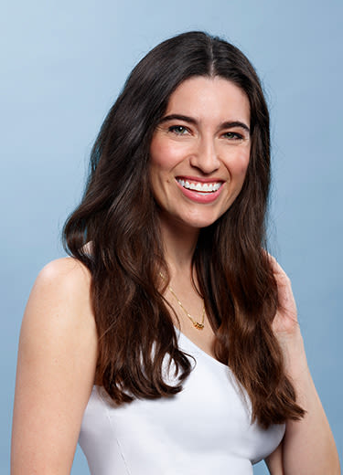 black haired woman smiling over a blue background