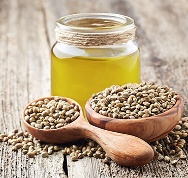 Hemp raw oil and seeds on wooden board