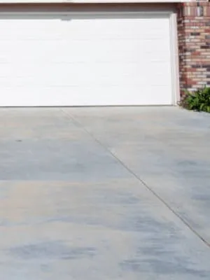 concrete driveway, white garage door, brick exterior