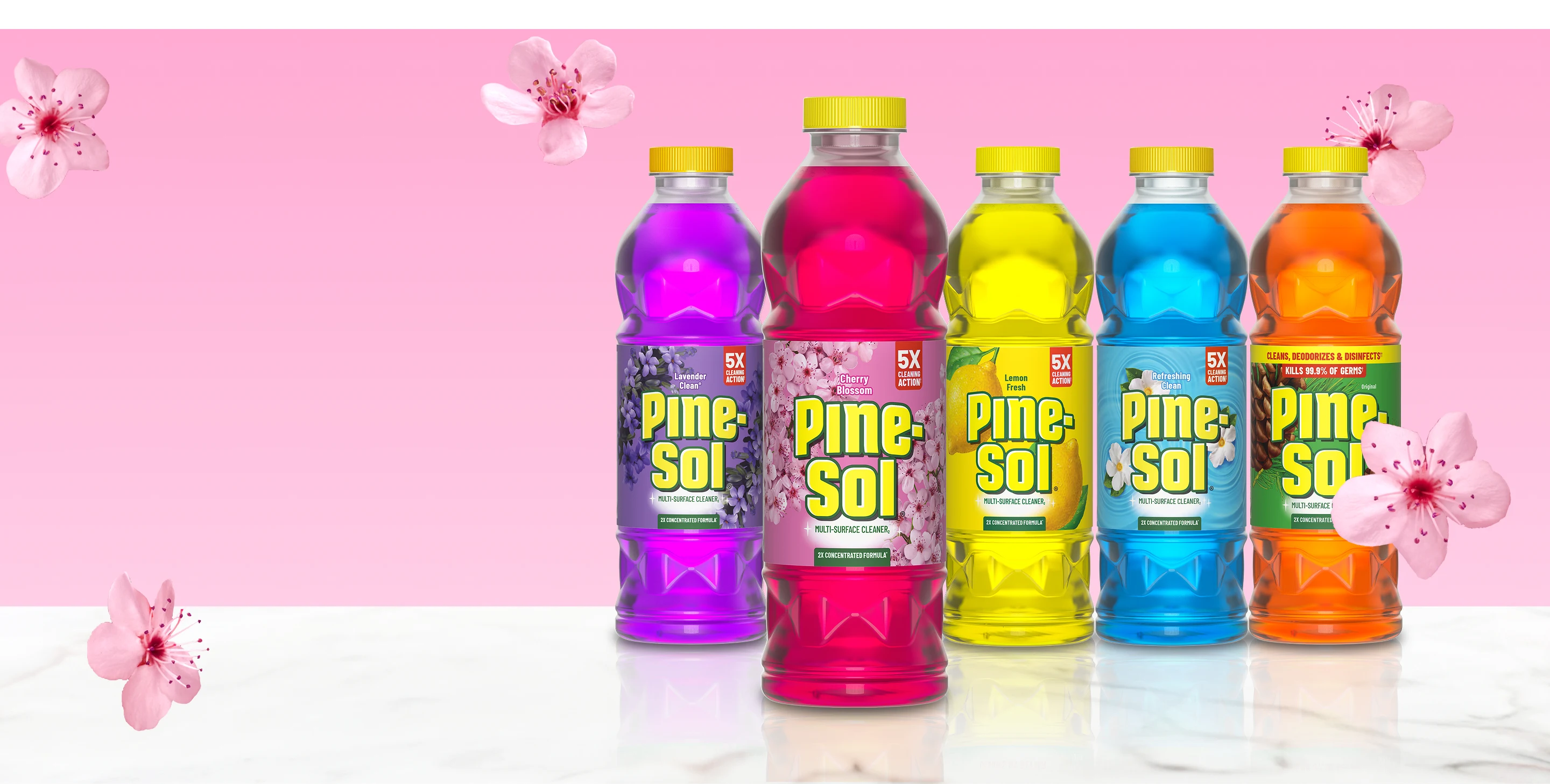 Línea de botellas de limpiador Pine-Sol en 5 aromas sobre superficie de mármol con acentos de flor de cerezo sobre fondo rosa.