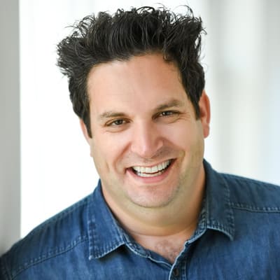 Portrait of man smiling while wearing a dark blue button up shirt shirt