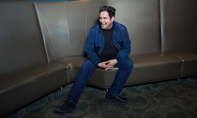 Smiling man sitting on couch looking to the side