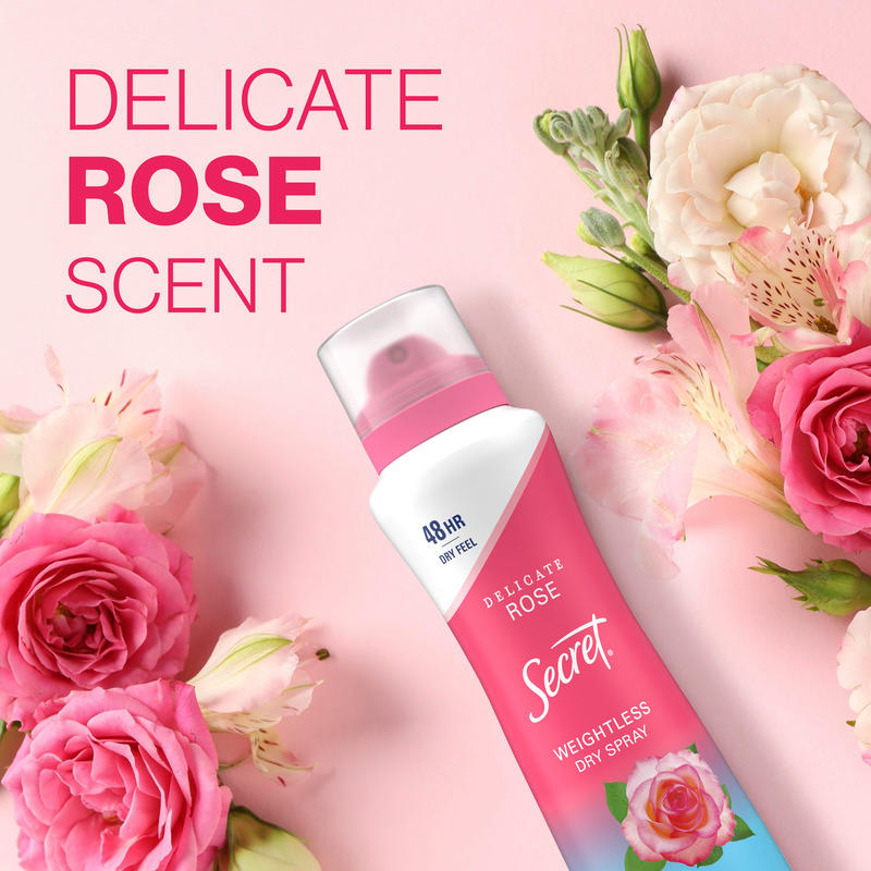 Weightless dry spray by Secret featuring delicate rose scent, surrounded by pink floral accents on a soft pastel background. Ideal for freshening up