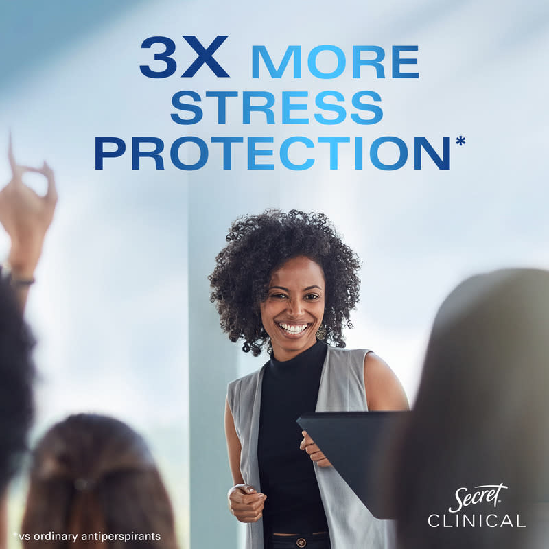 Smiling woman in professional attire presenting in an office setting, promoting three times more stress protection from Secret Clinical