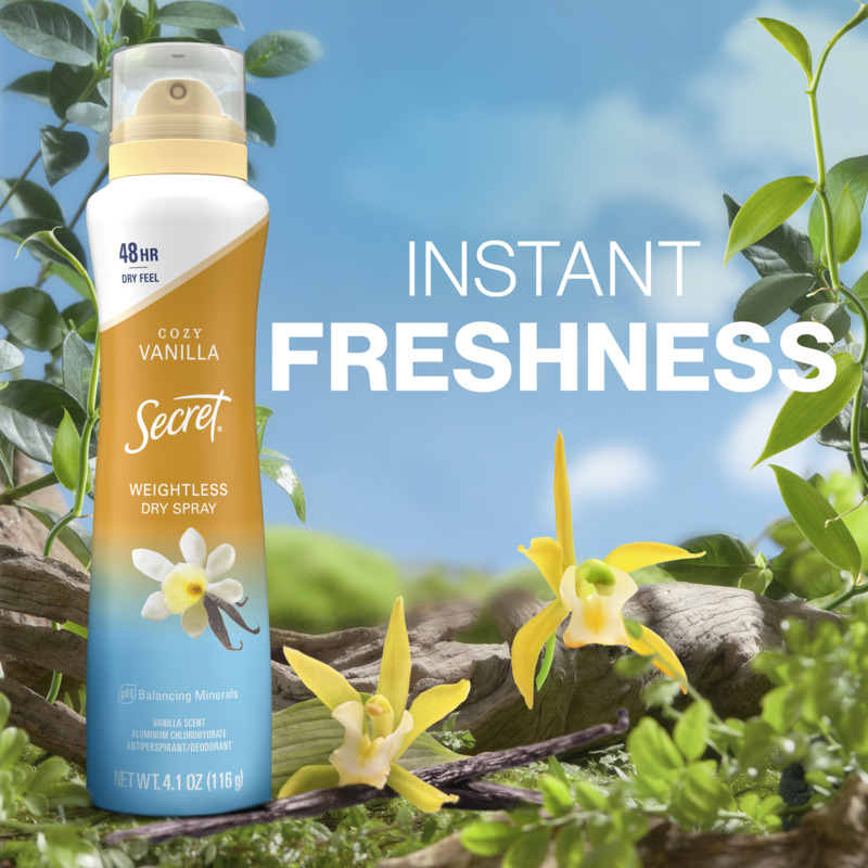 A bottle of Secret Cozy Vanilla weightless dry spray, surrounded by greenery and vanilla flowers, showcasing instant freshness for 48 hours