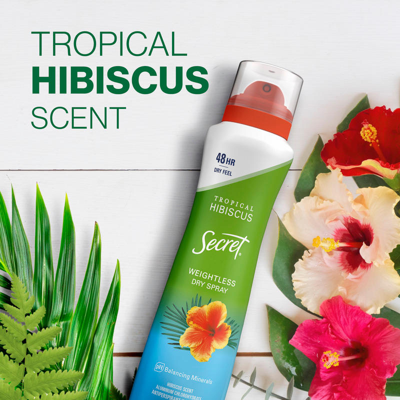 Tropical hibiscus scented deodorant spray with a weightless feel, surrounded by vibrant hibiscus flowers and green leaves on a wooden background