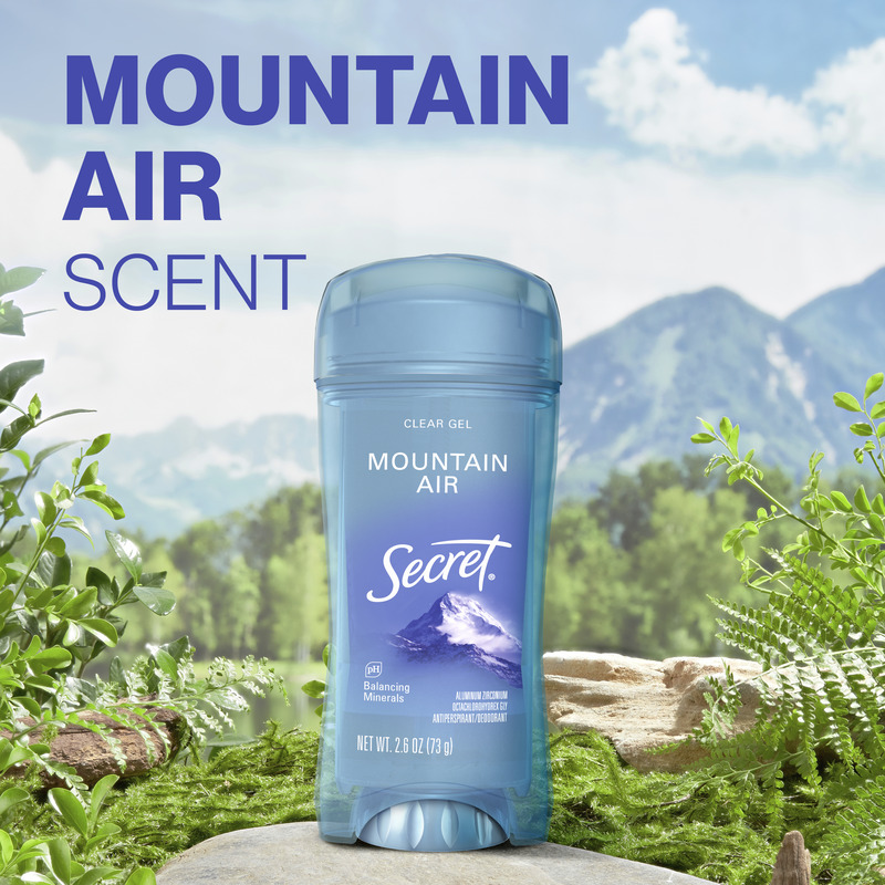 Mountain air scent. Secret clear gel deodorant with Mountain Air scent surrounded by natural greenery and a scenic mountain backdrop