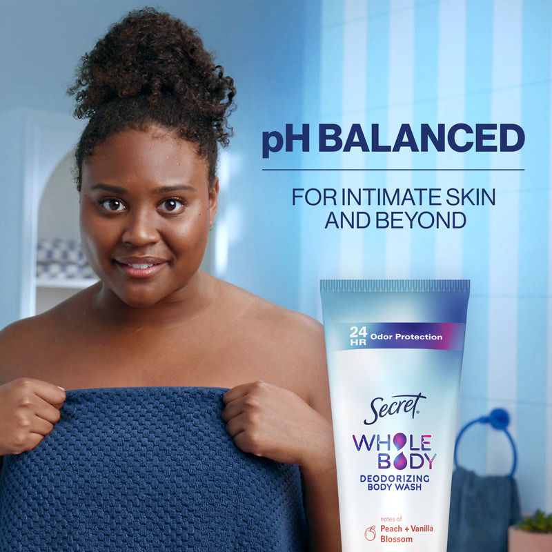 Woman holding a blue towel, promoting Secret Whole Body Deodorizing Body Wash with pH balanced messaging