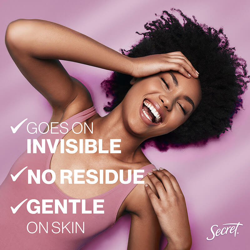 Woman with curly hair smiling, showcasing skincare benefits: goes on invisible, no residue, gentle on skin from Secret brand