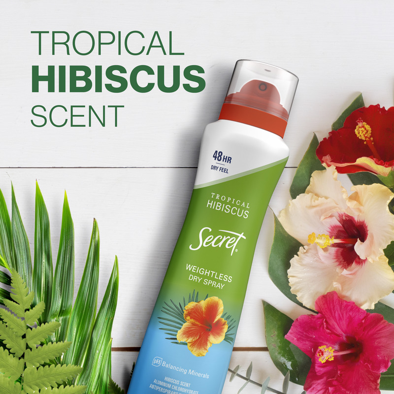 Tropical hibiscus scented deodorant spray with a weightless feel, surrounded by vibrant hibiscus flowers and green leaves on a wooden background