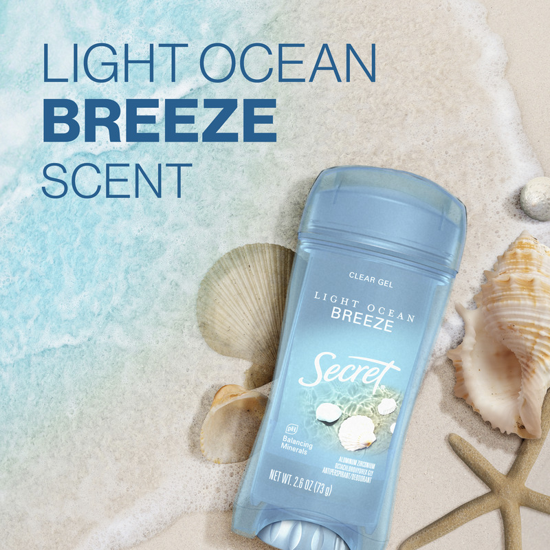 Secret clear gel deodorant with Light Ocean Breeze scent displayed on sandy beach with seashells and ocean background, reflecting fresh coastal vibe