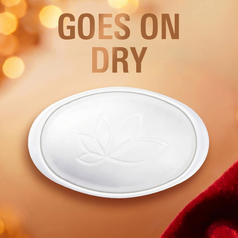 Dry solid deodorant seen from the top with a floral design, emphasizing the phrase "Goes on Dry" in a festive setting