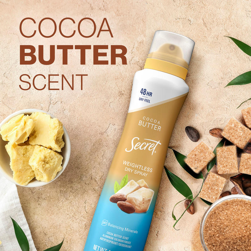 Cocoa butter scented dry spray in a bottle on a textured background, alongside cocoa butter chunks and sugar cubes for a natural feel