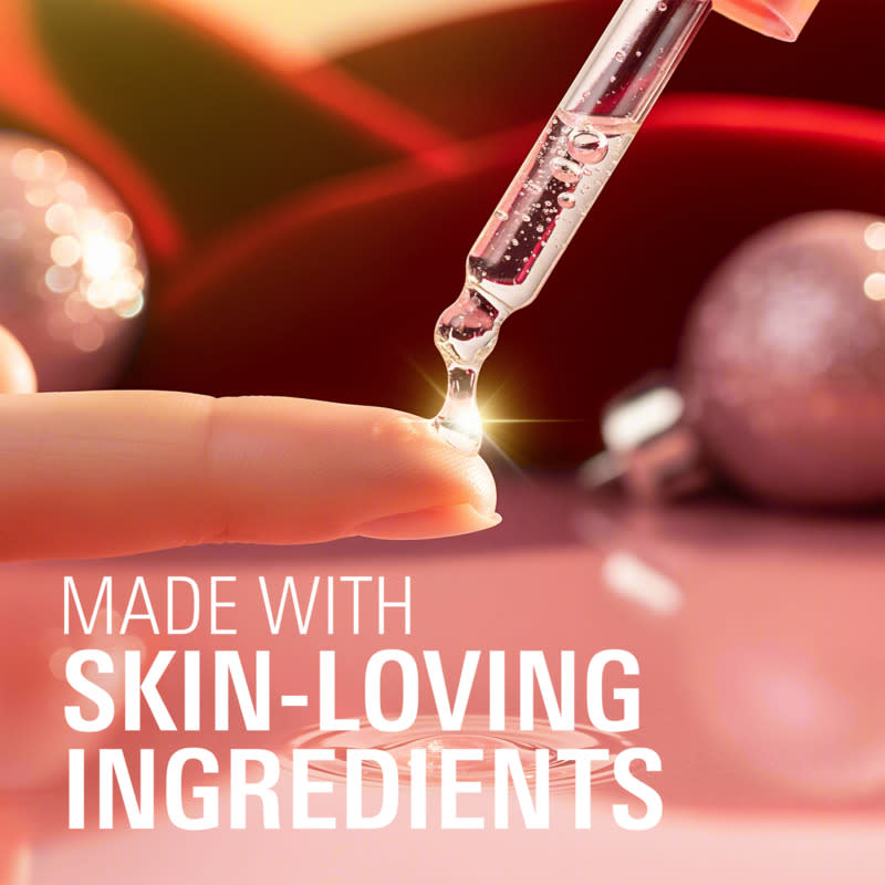 Dropper applying skin-loving ingredients onto a fingertip in a beautifully lit setting