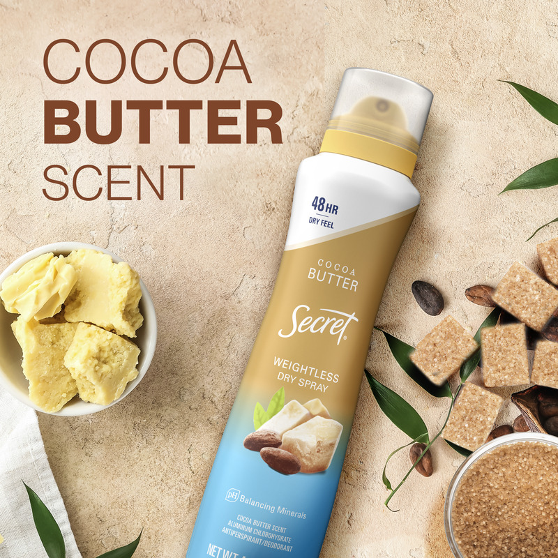 Cocoa butter scented dry spray in a bottle on a textured background, alongside cocoa butter chunks and sugar cubes for a natural feel