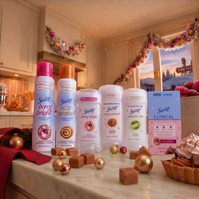 Six Secret deodorants displayed on a countertop in a festive kitchen setting with treats and decorations