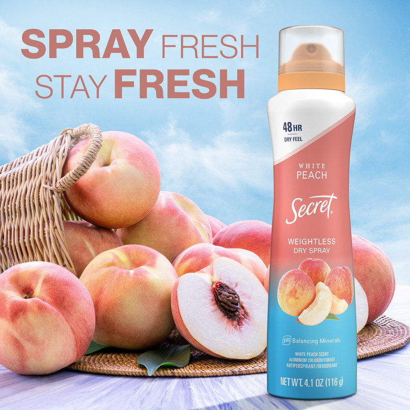 Secret weightless dry spray in white peach scent with fresh peaches in a basket on a light surface, promoting all-day freshness and comfort