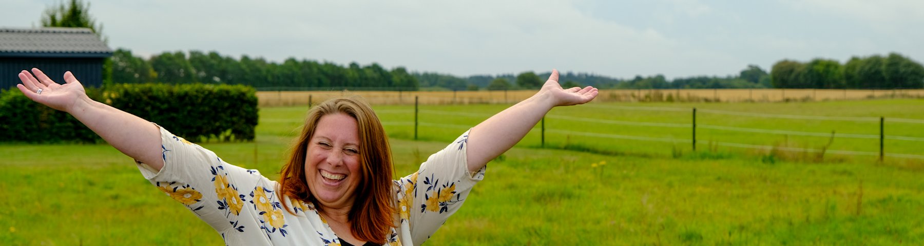 Sonja Hovmann Steffensen fra Jordrup står på en ledig byggegrund og rækker armene op og ud til siden