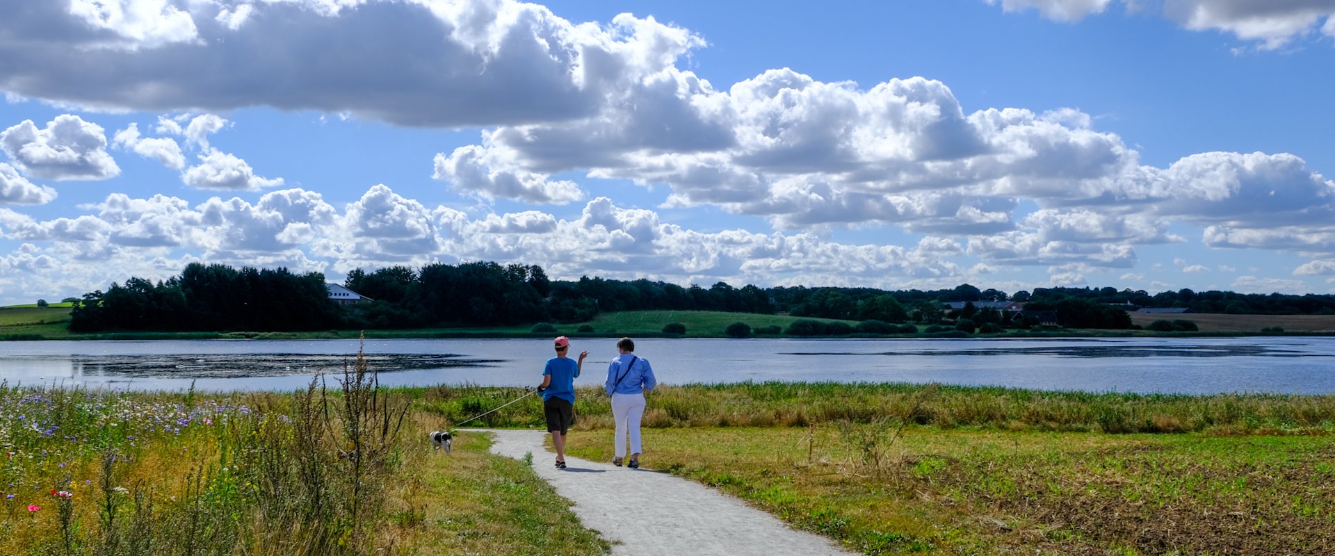 To personer spadserer ad stien fra udstykningen Søvænget ned til Ødis Sø.