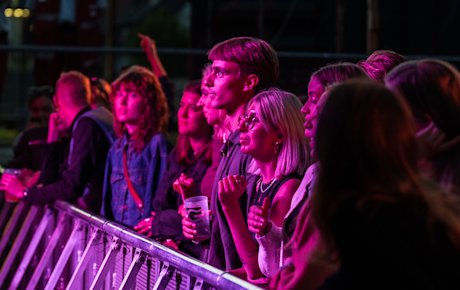 Publikum står ved scenekanten og lytter til musik