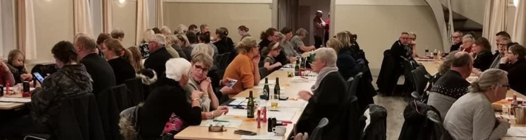 Bankospil i Medborgerhuset i Viuf, hvor folk sidder ved lange borde med spilleplader, øl og kaffe