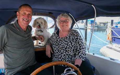 Jens Kristian og Kirsten sidder i cockpittet på deres båd med hunden Max bag sig i bagruden.