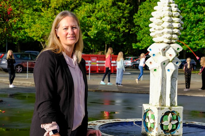 Skoleleder Lisbeth Askjær-Hansen ved vandfontænen i skolegården på Fynslund Skole og Børnehus.