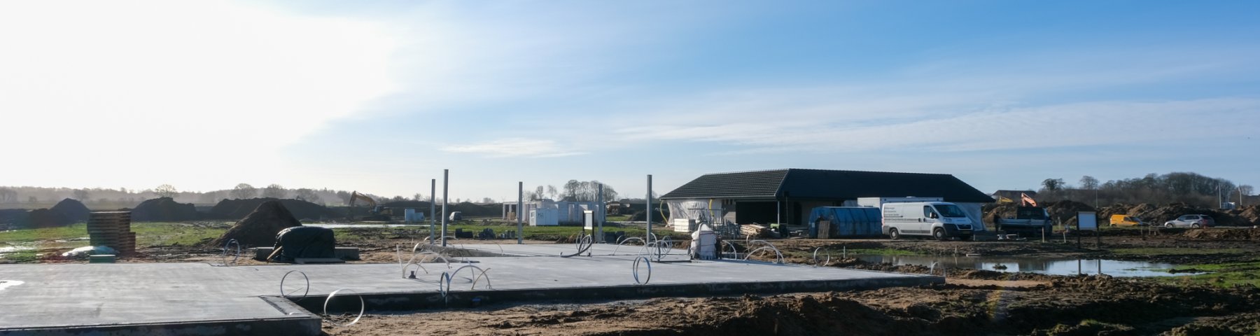 Det er en byggeplads i Vonsild ved Kolding. Fundamentet til et nyt hus er placeret til venstre i billedet. Bagved og til højre er et nybygget hus. 