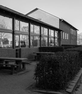Vonsild Skole set udefra med borde- og bænkesæt langs vinduesfacade