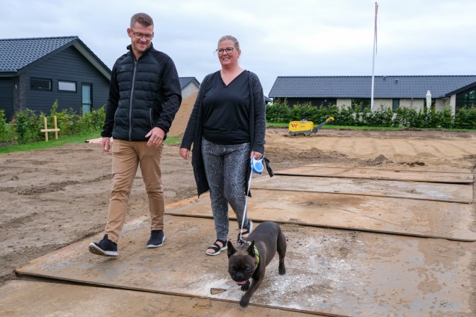 Thomas og Christina Graugaard-Nielsen går tur med hunden Svend på deres byggegrund på Vesterengen i Viuf